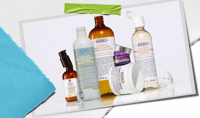 En samling av Kiehl's hudvårdsprodukter, inklusive serum, rengoringsmedel och fuktkramer, visade på en texturerad bakgrund.