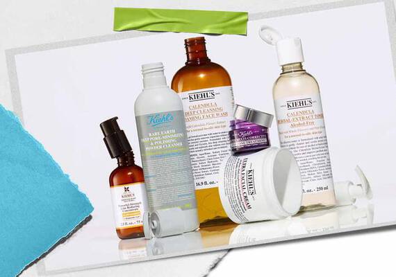En samling av Kiehl's hudvårdsprodukter, inklusive serum, rengoringsmedel och fuktkramer, visade på en texturerad bakgrund.