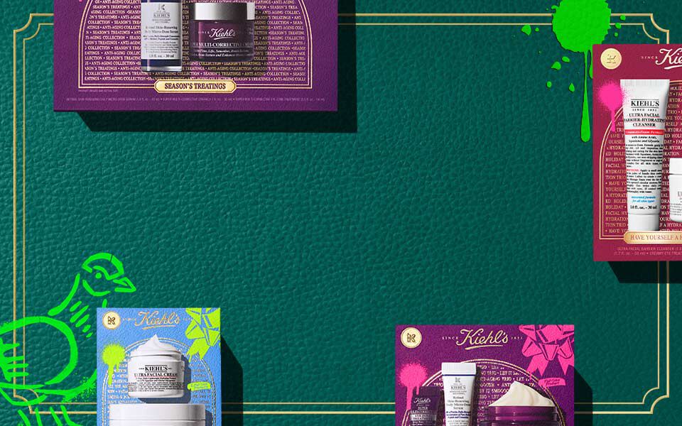Horisontell banderoll med en morkgron texturerad bakgrund och guldfargade kantlinjer, med fargglada Kiehl’s presentaskar i rosa, blått och lila, som var och en visar hudvårdsprodukter. Grona konstnarliga accenter syns på båda sidor.