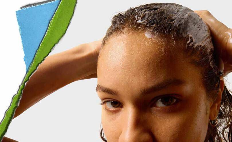 En person med vått hår applicerar en hårprodukt, med en fargglad sonderriven papperssektion i bakgrunden.