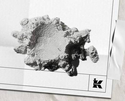 Ett texturerat, oregelbundet format vitt mineral- eller materialfragment vilande på en ljus bakgrund, med en liten logotyp langst ned till hoger.