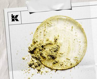 En cirkular flack av ljus gradde med en texturerad hog av gront pulver, presenterad på ett vitt ark markt med en logotyp.