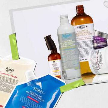 En samling av Kiehl's hudvårdsprodukter, inklusive lotioner och serum, konstnarligt arrangerade med livfulla forpackningar och etiketter synliga.