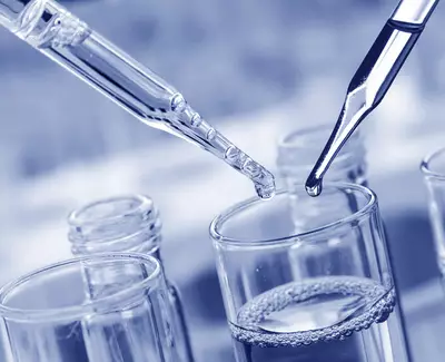 Two pipettes are positioned above a glass container filled with a clear liquid, with droplets poised to be released. The image has a blue-toned filter.