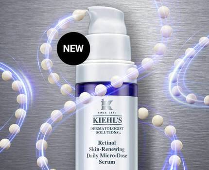 En flaska med Kiehl's Retinol Skin-Renewing Daily Micro-Dose Serum på en metallisk bakgrund, omgiven av en abstrakt representation av molekyler.