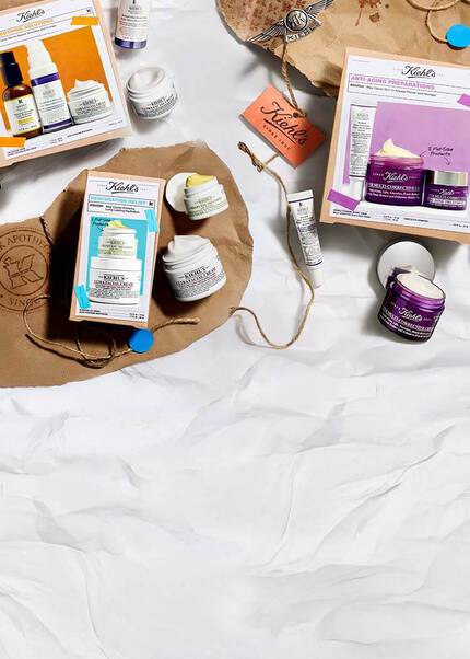 Ett sortiment av Kiehl's hudvårdsprodukter, inklusive fuktighetskramer och serum, visas på en snygg uppsattning med forpackning och etiketter.