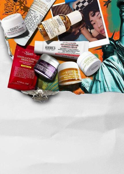 Ett sortiment av Kiehl's hudvårdsprodukter konstfullt arrangerade på en livlig orange bakgrund som forestaller Frihetsgudinnan.