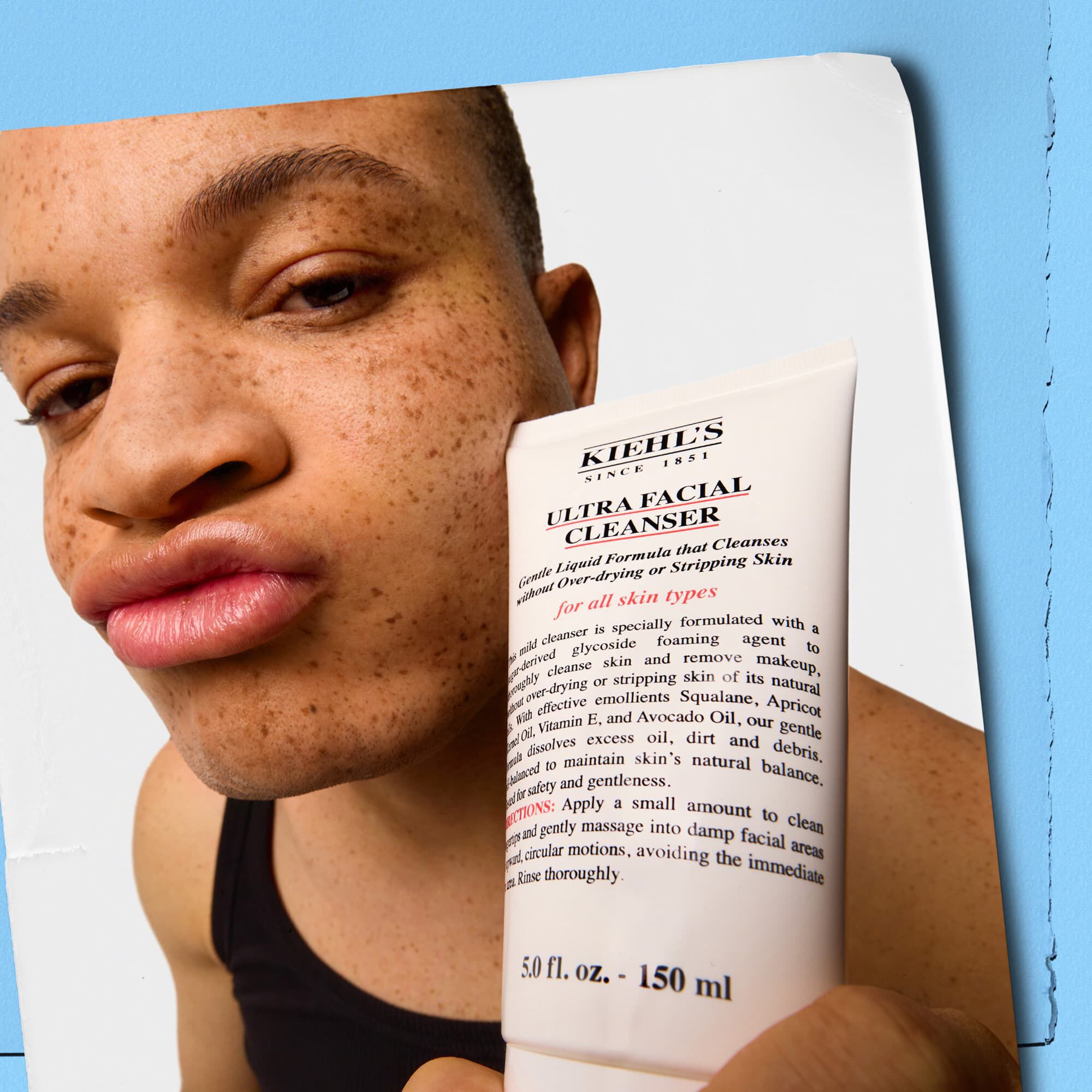 Modell som håller en tub Kiehl's Ultra Facial Cleanser