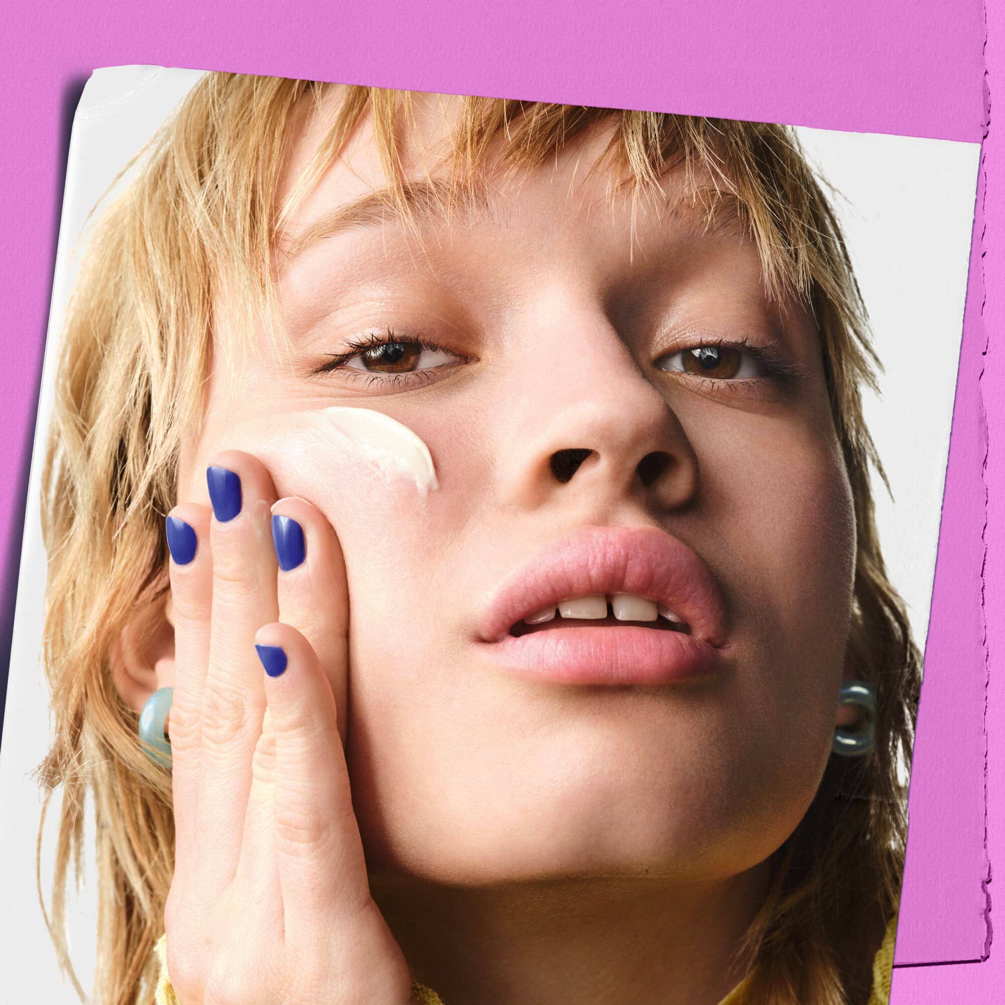 Modell som applicerar Kiehl's Super Multi-Corrective Cream på kinden