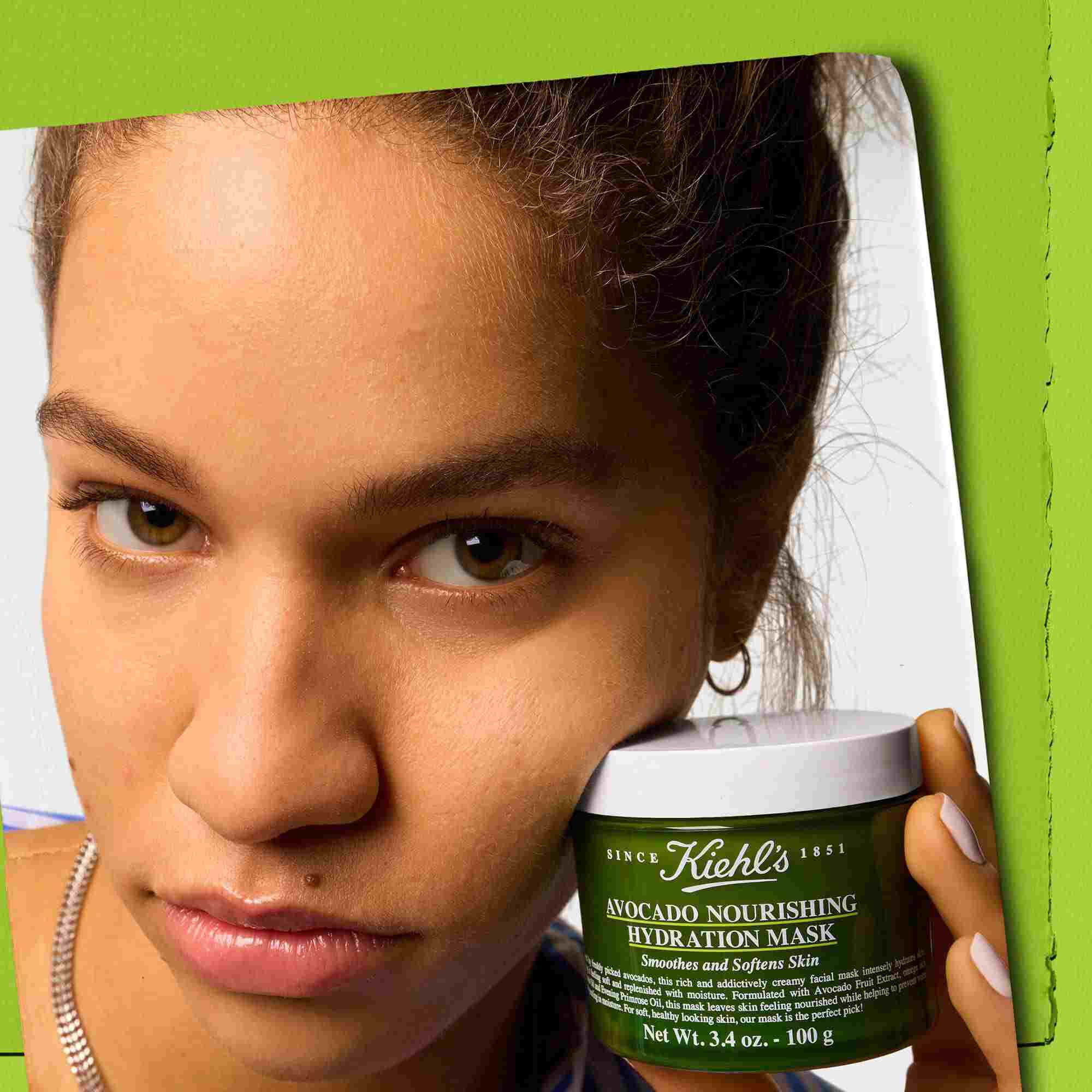 Modell som håller en burk Kiehl's Avocado Nourishing Hydration Mask – gor huden slat och mjuk