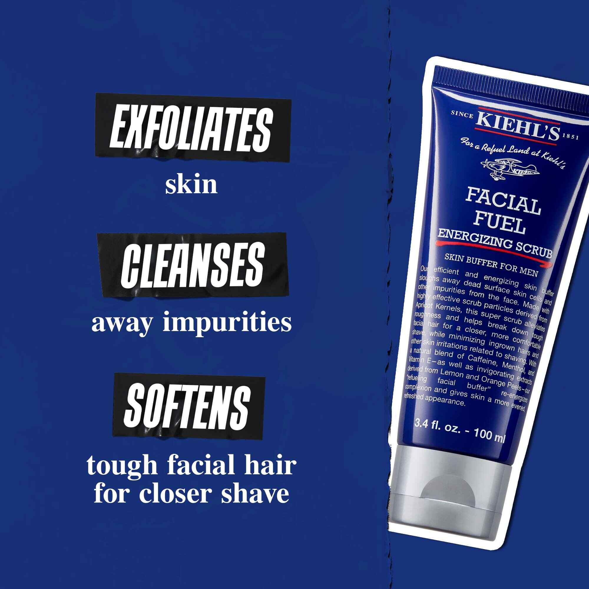 Tub med Facial Fuel Energizing Scrub mot en morkblå bakgrund. Texten lyder: "Eksfolierar huden, rengor orenheter och mjukar upp grova ansiktshår for en narmare rakning."