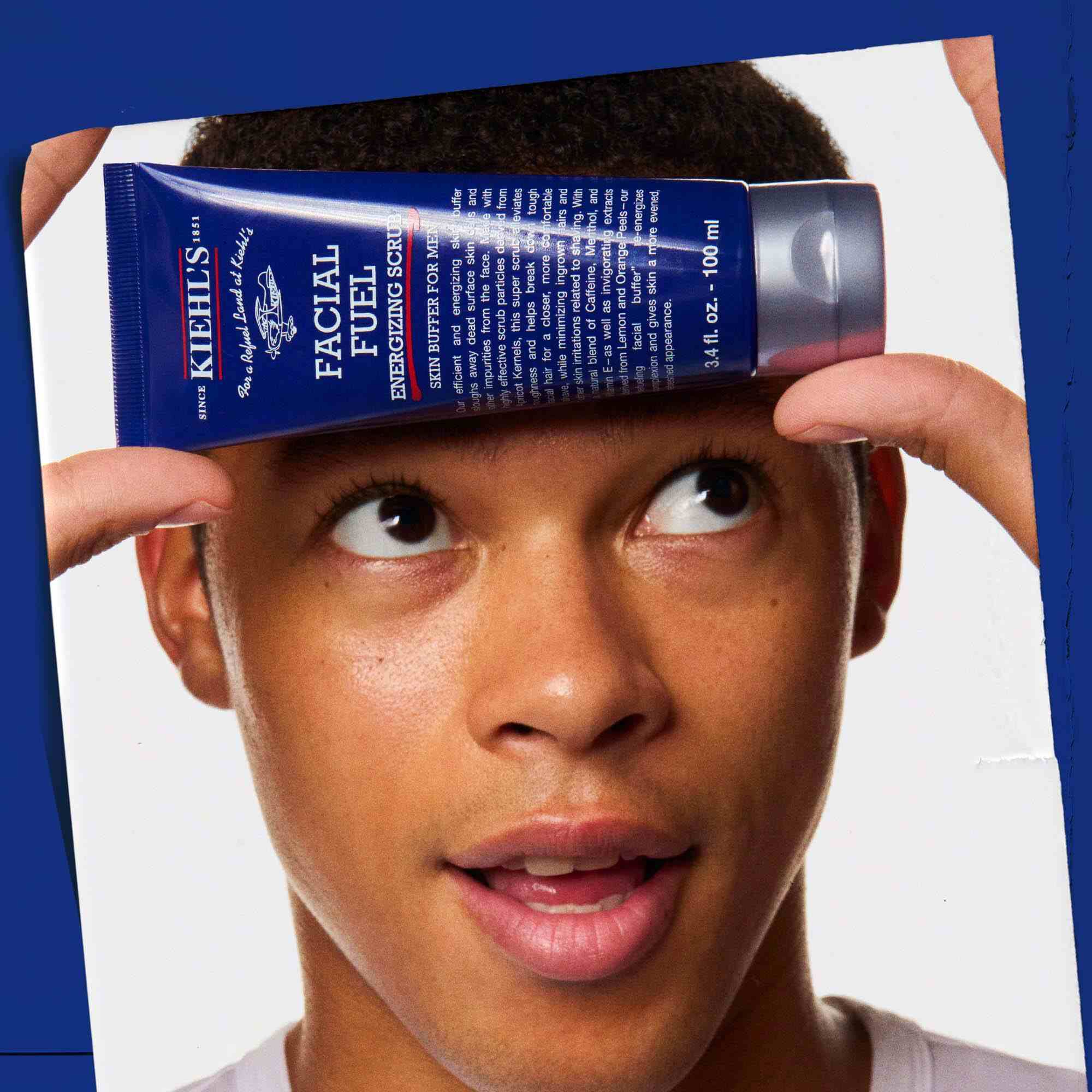 Facial Fuel Energizing Scrub hålls i handen, vilket visar dess anvandning.