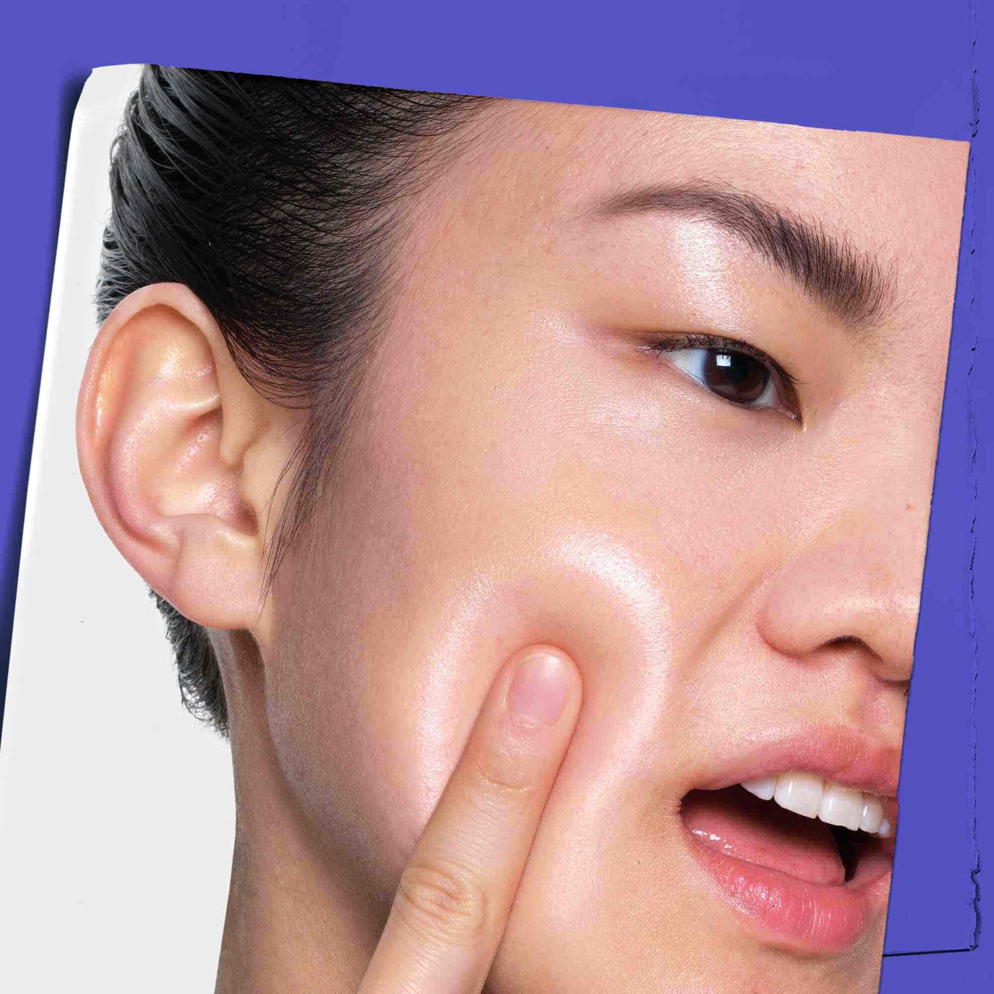 En person som applicerar Clearly Corrective Dark Spot Solution på huden.