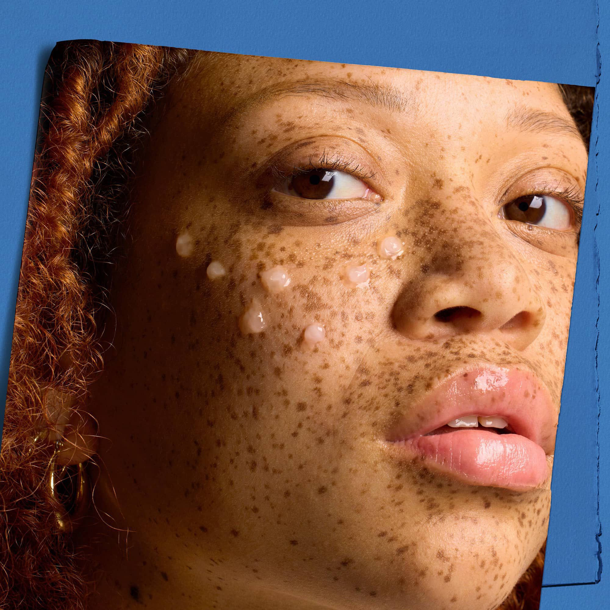 Modell med droppar av Kiehl's Hydro Plumping Serum Concentrate i ansiktet