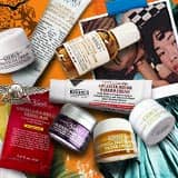 Ett sortiment av Kiehl's hudvårdsprodukter konstfullt arrangerade på en livlig orange bakgrund som föreställer Frihetsgudinnan.